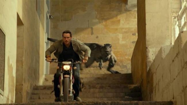 Owen Grady pilota una Montesa Cota 4Ride mientras un Velociraptor le persigue en la película Jurassic World Dominion. Universal Pictures.
