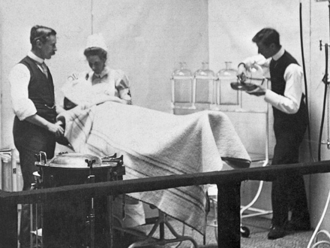 1890: Un modelo de un paciente sometido a cirugía en un quirófano de la era victoriana tardía. Foto de Hulton Archive / Getty Images