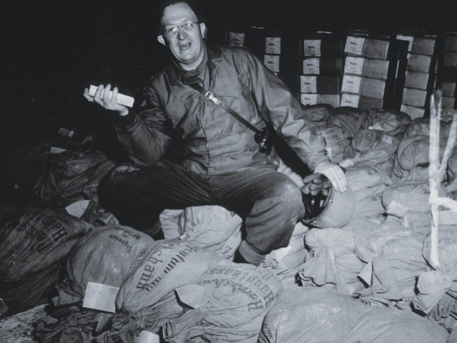 Soldado estadounidense posando junto a los lingotes de oro encontrados en la mina de sal de Heilbronn. Imagen: Getty Images