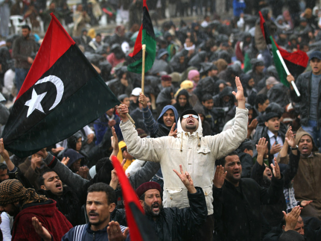 Una concentración llamada a las armas para luchar contra el líder Muammar Gaddafi reza bajo la lluvia el 4 de marzo de 2011. / John Moore. Getty Images