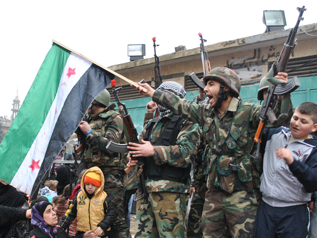Un desertor del Ejército ondea la bandera siria de la revolución en la provincia de Homs el 26 de enero de 2012. / GTRES