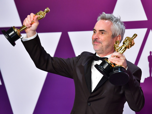 Alfonso Cuarón sostiene sus Óscar por 'Roma' / Getty